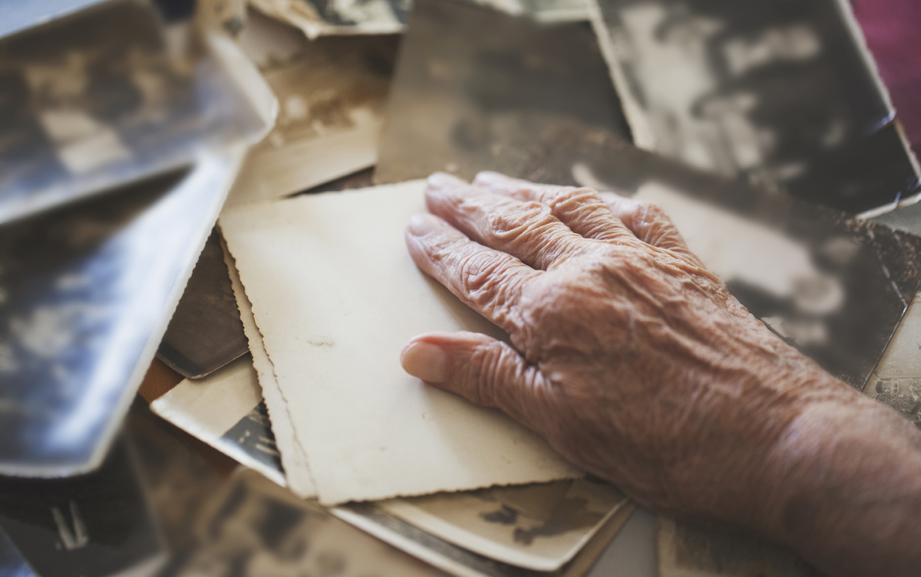 hand resting on old letters and photographs